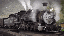 a steam train is pulling into a train station on a track .