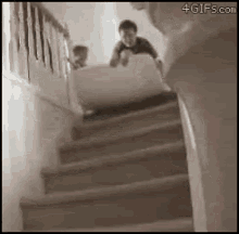 a child is sliding down a set of stairs with a box .