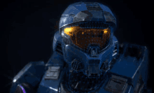 a close up of a blue helmet with a yellow glowing lens