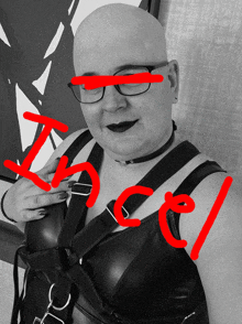 a bald woman wearing glasses and a choker has the word incel written on her chest