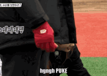 a person wearing a red glove with the word hgngh puke on it