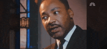 a close up of a man in a suit and tie talking