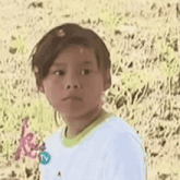 a young boy wearing a white shirt with the number 2 on it .