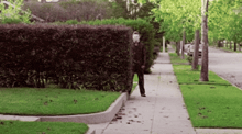 a man in a mask is walking down the sidewalk
