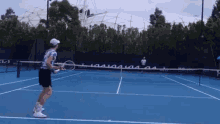 a man is playing tennis on a blue court with a sign that says ' australian open ' on it