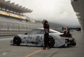 a man leans against a race car with the number 35 on the side