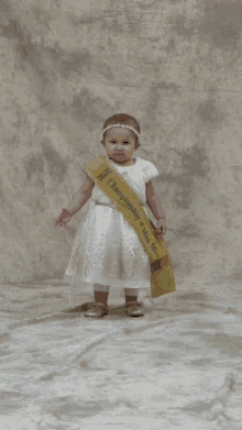 a little girl in a white dress is wearing a sash that says championship of miss texas