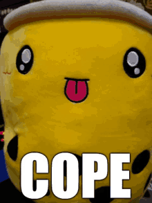 a yellow stuffed animal with a tongue sticking out and the word cope written on it