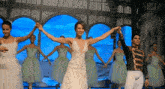 a woman in a wedding dress is dancing with other dancers