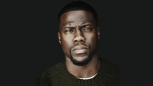 a close up of a man 's face with a beard wearing a green sweater .