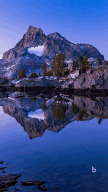 a mountain is reflected in a lake with the letter b on the bottom left