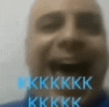 a blurry picture of a man 's face with the words kkk written in blue letters .