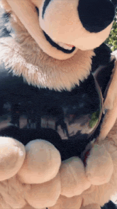a close up of a mickey mouse mascot holding a balloon