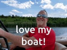 a man in a red shirt is driving a boat with the words " love my boat " written above him