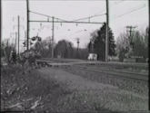 a black and white photo of a train track with a train coming down the tracks .
