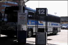 a greyhound bus is parked next to a sign that says whistler pemberton