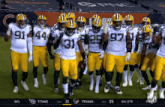 a group of green bay packers players standing on a field