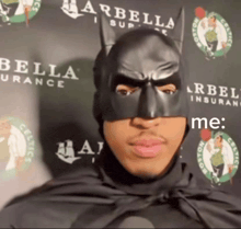 a man in a batman mask stands in front of a wall that says bella