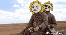 two men are riding a bike with sunflowers on their faces ..