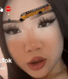 a girl has a school bus on her forehead and a stop sign