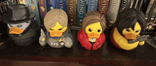 four rubber ducks are lined up on a shelf and one of them has a r.p.d. uniform on