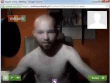 a man without a shirt is on a video call with a mbank logo on the screen