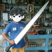 a man in a blue shirt is holding a large knife in front of a shelf .