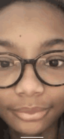 a close up of a woman 's face wearing glasses .