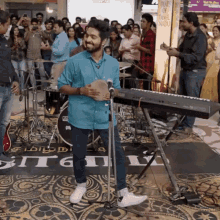 a man playing a keyboard in front of a crowd with a sign that says beats of tamilnadu on it