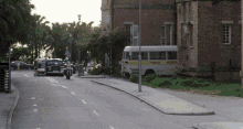 a row of buses are parked on the side of the road including one that says ' bus service ' on the side