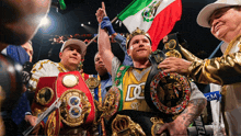 a boxer wearing a dc shirt holds up his championship belt