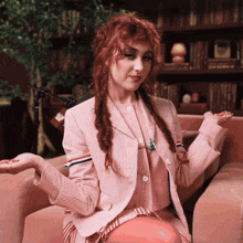 a woman with red hair is wearing a pink and white striped suit