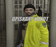 a man in a yellow jacket is standing in front of a jail cell with the words upiskany kokot written above him