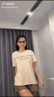 a woman wearing glasses and a t-shirt that says gucci