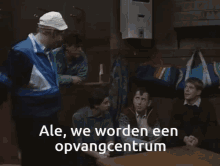 a group of men sitting around a table with ale we worden een opvangcentrum written in white