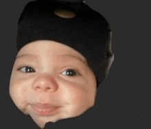 a close up of a baby 's face with a black hat