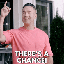 a man in a pink shirt is pointing up and saying there 's a chance