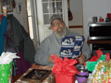 a man sits at a table with a christmas wrapping paper that says ' christmas ' on it