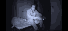a man is sitting on a mattress with a sleeping bag on it