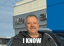 a man is standing in front of a murray building and says i know