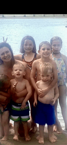 a group of children posing for a picture with a woman in the middle