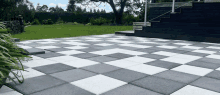 black and white checkered tiles on a patio with stairs in the background