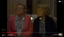 two older women are sitting on a couch in a video that is being played on youtube