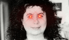 a black and white photo of a woman 's face with red stars coming out of her eyes