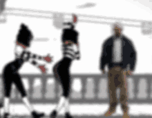 a blurry picture of a man standing next to two women dancing