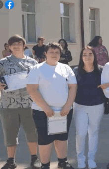 a group of people are standing in front of a building with a facebook logo in the corner