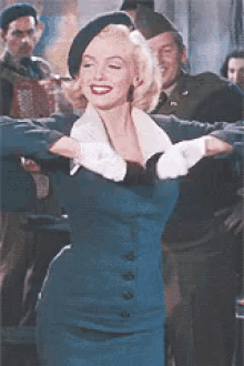 a woman in a blue dress and white gloves is dancing in front of a group of men in military uniforms