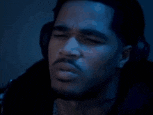 a close up of a man 's face in a dark room with headphones on .