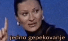 a woman is making a funny face and pointing up with the words jedno gepekovanje in the background .