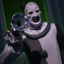 a clown is holding a trumpet in front of a green door
